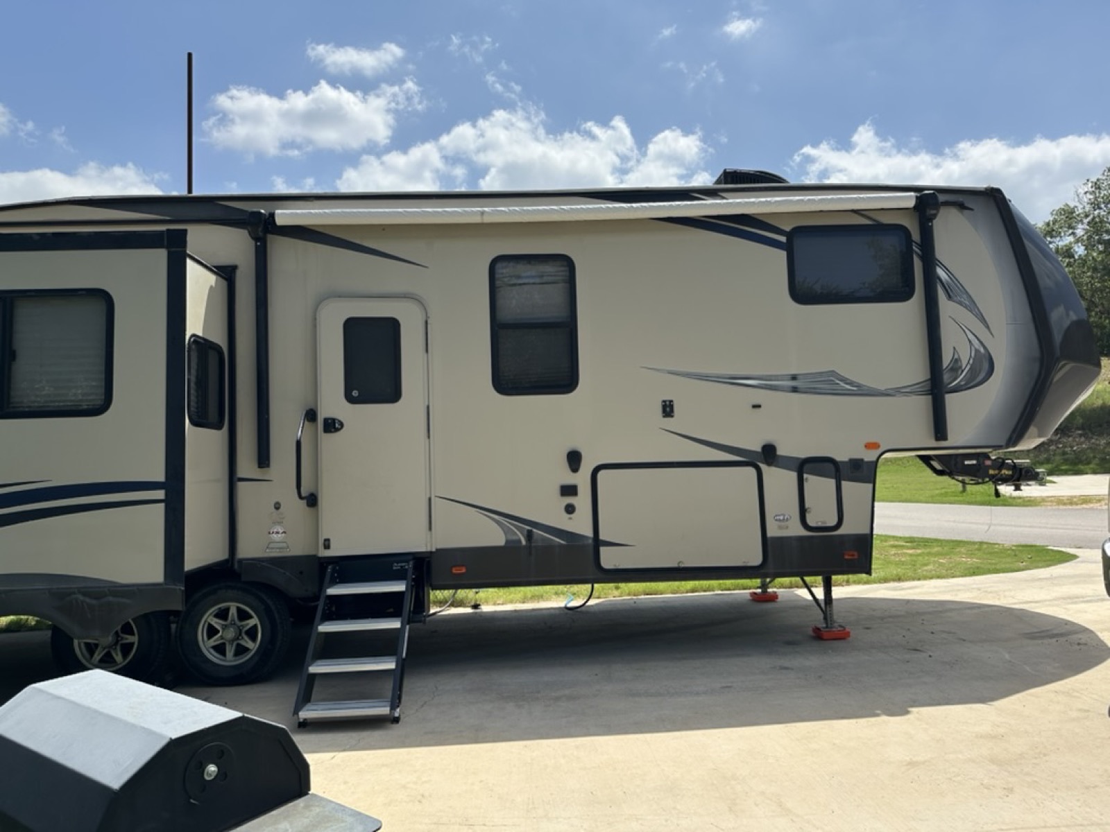 Fifth wheel with awning extended and entry steps down, ready for a stay