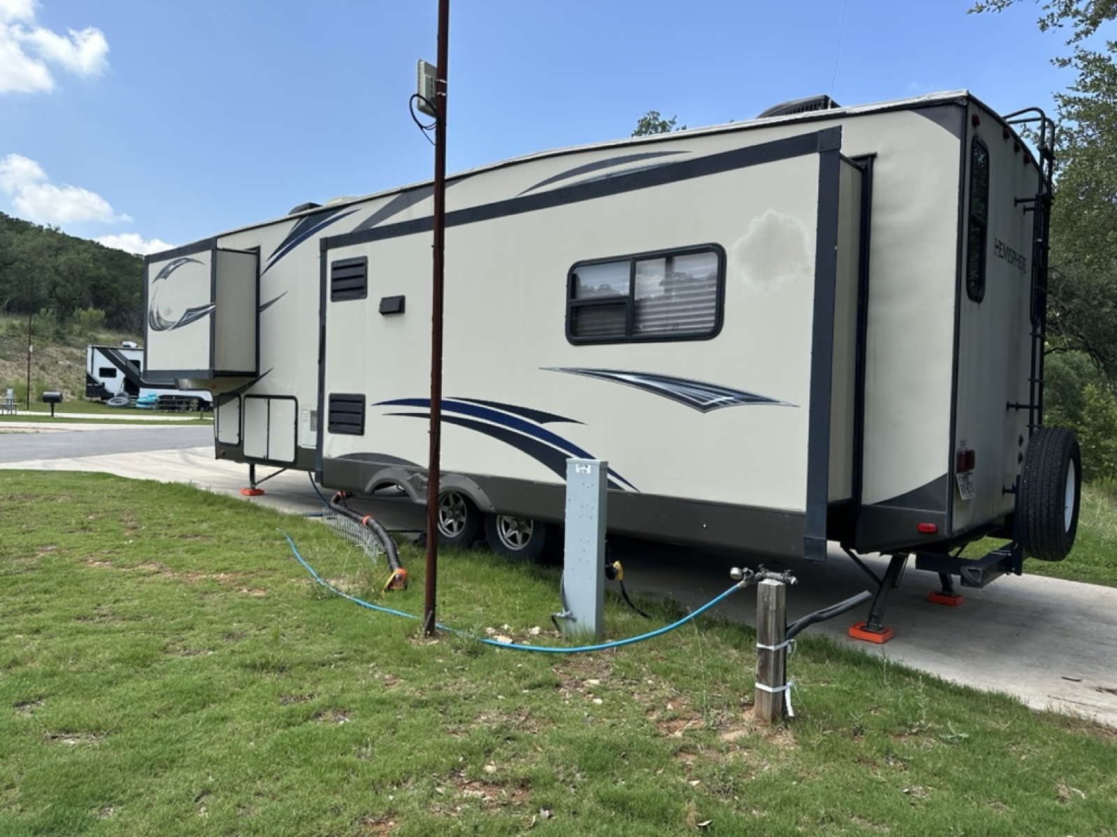 Hemisphere fifth wheel leveled on a concrete pad with water and power connected